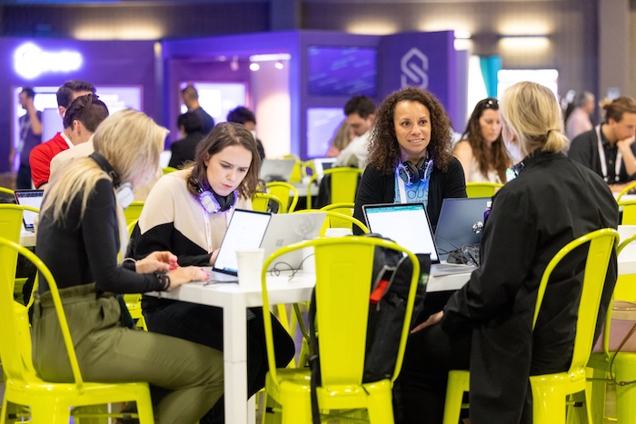 Trade show attendees wearing silent headphones while working on a project