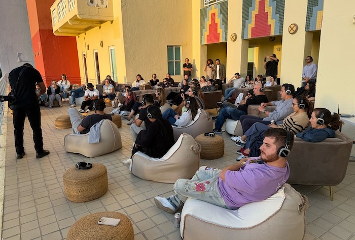 Meditation attendees wearing silent headphones while focused on a presenter