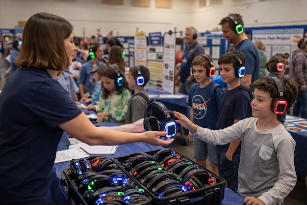 School and university attendees wearing silent headphones while focused on a presenter